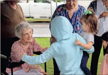  ?? Olivia Morley ?? Martha Lee Rogers (from left) greets her granddaugh­ter’s nieces Charleigh Feizert and Elliot Patrick at her 100th birthday party Wednesday in Garden Lakes.
