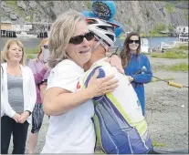  ?? JOE GIBBONS/THE TELEGRAM ?? Martin Denonville is hugged by his wife, Carrie Lee, Monday in Quidi Vidi Village.