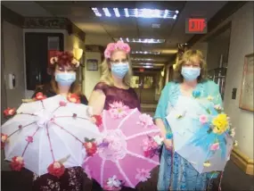  ?? COURTESY OF MANATAWNY MANOR ?? Manatawny Manor activities assistants Anastasia Stoulis and Ginny Rathman and activities director Janet Swiecicki hold festively decorated umbrellas during a Flores de Mayo celebratio­n on Mother’s Day. The activities department of the senior living facility in East Coventry Township, Chester County, is coming up with creative ways to engage residents during the COVID-19pandemic.