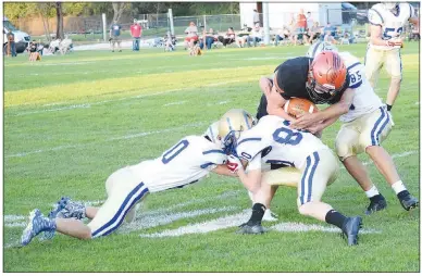  ?? Westside Eagle Observer/MIKE ECKELS ?? A pack of Bulldogs takes down a lone Eagle runner during the first quarter of the Jasper-Decatur varsity football contest at Eagle Stadium in Jasper, Mo, Friday night. The Eagles took the win, 72-12, over the Bulldogs in Decatur’s first football game of 2021.