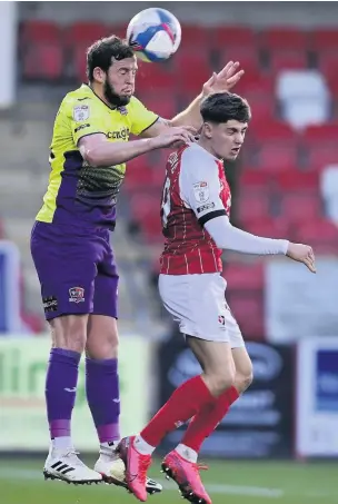  ??  ?? Exeter’s Pierce Sweeney wins a header against George Lloyd