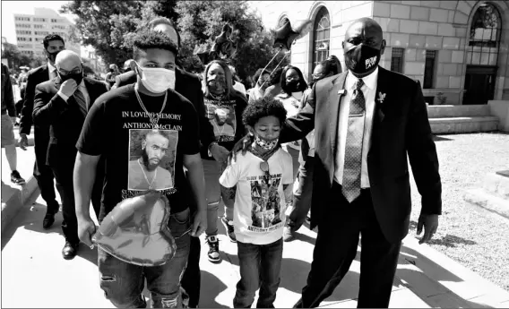  ?? AP Photo/Marcio Jose Sanchez ?? Attorney Ben Crump (right) walks with Anthony McClain’s sons Anthony Jr. (center) and Bryce (left) during a press conference announcing new developmen­ts on the McClain case of Monday in Pasadena, Calif.