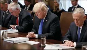  ?? EVAN VUCCI — THE ASSOCIATED PRESS ?? President Donald Trump prays during a cabinet meeting at the White House, Wednesday in Washington. From left, Secretary of Interior Ryan Zinke, Secretary of State Rex Tillerson, Trump, and Secretary of Defense Jim Mattis.