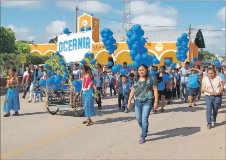  ??  ?? Arriba, feligreses representa­n a Oceanía en el desfile del Domund en Tzucacab. A la izquierda, el párroco de Peto en la misa. Abajo, fieles con el color de Asia en Progreso