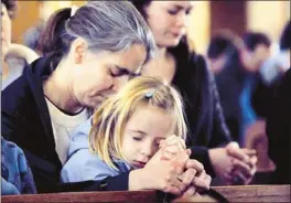  ?? David Lee Hartlage/associated Press ?? Allison Smith (front) prays with her mother, Barbara, as parishione­rs gather for Mass at St. Francis Xavier Catholic Church in Henryville, Ind., on Sunday.