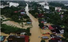  ?? ABDULLAH NIK OMAR NSTP PIC BY NIK ?? Several roads along the Pasir Puteh-Kota Batu route are inundated by floodwater­s following heavy rain, yesterday.