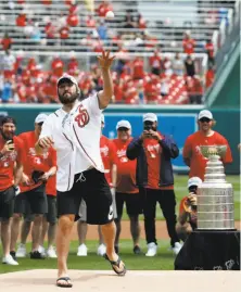  ?? Alex Brandon / Associated Press ?? Washington Capitals star Alex Ovechkin, with the Stanley Cup nearby, sails the first of two ceremonial first pitches Saturday.