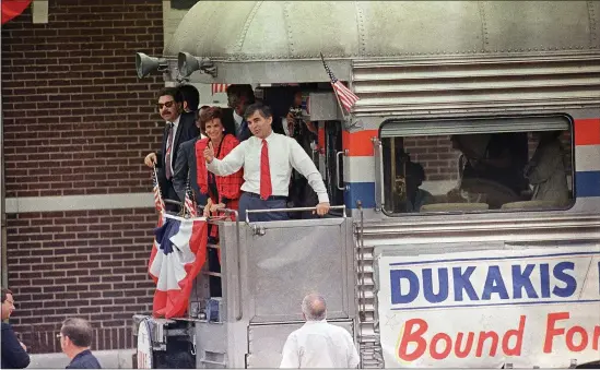  ?? JAMES A. FINLEY — THE ASSOCIATED PRESS ?? Michael Dukakis, Democratic candidate for president waves to supporters upon his arrival by train, Aug. 19, 1988in Bismarck, Mo. Joining Dukakis is his wife Kitty.