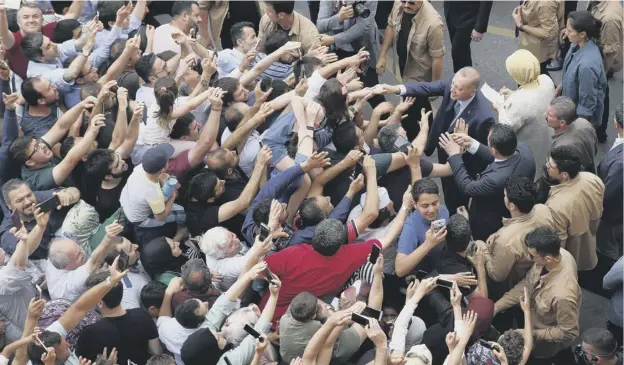  ?? PICTURE: AP ?? 0 Tayyip Erdogan, right, shakes hands with supporters after casting his ballot in Turkey’s elections at a polling station in Istanbul