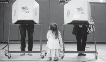  ?? [PHOTO BY STEVE JACOBS, THE POST-STAR VIA AP] ?? Brigit Mulligan, right, casts her vote as her daughter, Giovanna Candido, watches Tuesday at the Sanford St. School in Glens Falls, N.Y.