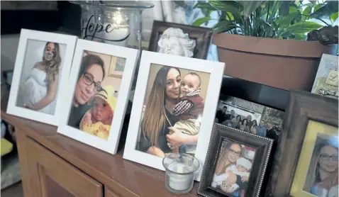  ?? MARK LENNIHAN/ THE ASSOCIATED PRESS ?? In this Feb. 9 photo, Chelsea Cobo holds her son, Christophe­r, in framed photos arranged as a shrine at her home in the Brooklyn borough of New York. Chelsea disappeare­d in May 2016. New DNA science developed to identify the skeletal remains of the 9/...