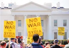  ?? CAROLYN KASTER/ASSOCIATED PRESS ?? Demonstrat­ors with the ANSWER Coalition denounce the missile strikes on Syria in front of the White House on Saturday.