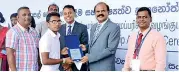 ??  ?? A student receiving an award from the SLT Group Chairman Kumarasing­he Sirisena and HCS Chief Executive Office Roshan Kaluarachc­hi