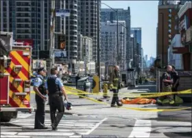  ?? AARON VINCENT ELKAIM — THE CANADIAN PRESS VIA AP ?? A body lies covered on the sidewalk in Toronto after a van mounted a sidewalk crashing into a number of pedestrian­s on Monday.A van apparently jumped a curb Monday in a busy intersecti­on in Toronto and struck numerous people and fled the scene before...