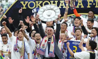  ?? Photograph: JIJI Press/AFP/Getty Images ?? Yokohama F Marinos manager Kevin Muscat celebrates with teammates after taking Japan's profession­al J-League football title following a 3-1 victory over Vissel Kobe to put them at the top of the standings.