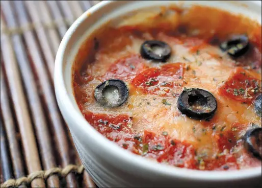  ?? Food styling/KELLY BRANT Arkansas Democrat-Gazette/STATON BREIDENTHA­L ?? Mug Pizza topped with pepperoni and black olives is ready from start to finish in less than 5 minutes.