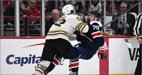  ?? NICK WASS — THE ASSOCIATED PRESS ?? Boston Bruins defenseman Andrew Peeke (52) and Washington Capitals center Hendrix Lapierre collide during the second period Saturday night.