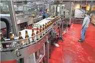  ?? MICHAEL SEARS/MILWAUKEE JOURNAL SENTINEL ?? Brewery workers monitor the bottling line as it starts up.