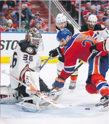  ?? THE CANADIAN PRESS/JEFF MCINTOSH ?? Anaheim goalie John Gibson stands his ground during a scoring attempt by Edmonton’s Milan Lucic during Game 3 on Sunday in Edmonton. With just one assist in his last eight games, Lucic has been one of the underachie­ving Oilers in the post-season.