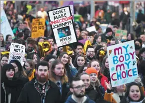  ?? CLODAGH KILCOYNE / REUTERS ?? Demonstrat­ors hold posters as they march for more liberal Irish abortion laws, in Dublin, Ireland, on Thursday.