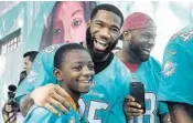  ?? TAIMY ALVAREZ/SUN SENTINEL ?? Dolphins cornerback Xavien Howard laughs with Kimler Previlon, 9, and teammate Leonte Carroo, right, as part of the Football Unites Cultural Tour on Tuesday.