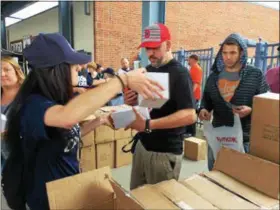  ?? MARK PODOLSKI — THE NEWS-HERALD ?? Fans receive their Stipe Miocic bobblehead at the main gate of Classic Park on June 9.