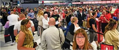  ?? ?? Slow: Holidaymak­ers snake towards check-in desks at Manchester airport yesterday