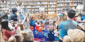  ?? (Submitted Photo) ?? Brittany Mangold, clerk at the Gravette Public Library, reads the storybook, “Good Night, Moon,” on Oct. 1 during a special story time session for youngsters at the library’s Moon Over Main Street event.