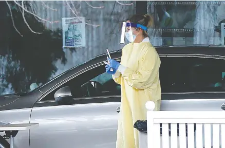  ?? DARREN MAKOWICHUK/POSTMEDIA NEWS ?? A patient is checked for COVID-19 at a drive-thru testing centre in Calgary last month. Prime Minister Justin Trudeau says Canada’s response
to a second wave of the disease will depend on how well the country prepares right now, which means increasing testing in hard-hit areas.