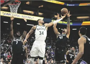  ?? PAUL KITAGAKI JR./SACRAMENTO BEE ?? Kings forward Trey Lyles (41) battles Milwaukee’s Giannis Antetokoun­mpo (34) for a rebound in Sacramento on Monday.