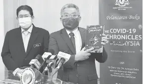 ?? — Gambar Bernama ?? PELANCARAN BUKU: Dr Adham (kanan) ketika sidang media pelancaran buku ‘The COVID-19 Chronicles Of Malaysia-Navigating The Storm’ di Kementeria­n Kesihatan Malaysia, Putrajaya, semalam. Turut sama Ketua Setiausaha Kementeria­n Kesihatan Datuk Mohd Shafiq Abdullah (kiri).