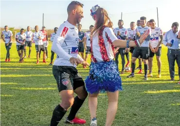  ?? JESÚS RICO ?? El lateral barranquil­lero Germán Gutiérrez baila en la práctica con la reina del Carnaval Valeria Abuchaibe.