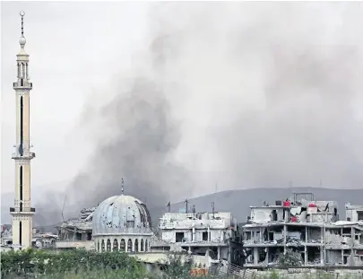  ?? AFP ?? Columnas de humo asoman por encima de los edificios en el bastión rebelde de Ghouta oriental