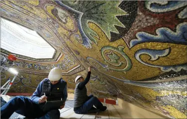  ?? ANDREW MEDICHINI — THE ASSOCIATED PRESS ?? Restorers Chiara Zizola, right, and Roberto Nardi work on the restoratio­n of the mosaics that adorn the dome of St. John’s Baptistery, one of the oldest churches in Florence, Italy.