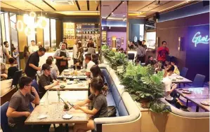  ?? FRIZAL/JAWA POS ?? JADI TREN: Pengunjung menikmati menu di Gioi, Surabaya. Saat ini generasi milenial terjuni bisnis F&B.