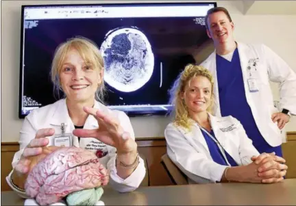  ?? PETER HVIZDAK / HEARST CONNECTICU­T MEDIA ?? Yale New Haven Hospital stroke program manager Karin Nystrom, left, with nurse navigators Kaile Neuschatz, center, and Kelsey Halbert, all of the Yale New Haven Hospital Stroke Center, with a brain scan showing a large stroke, shown at rear.