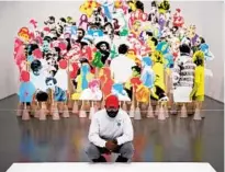  ?? CHRIS SWEDA/CHICAGO TRIBUNE ?? Sean Blakeney crouches down to look at a piece of artwork installed beside the Floating Museum’s Monument Reassembly at “The Long Dream” exhibit at the MCA in 2020.