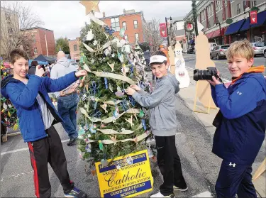  ?? Ernest A. Brown/The Call ?? From left, Tyler McDonald, 12, of Cumberland; Daniel Belisle, 10, of Woonsocket; and Devin Casson, 12, of Cumberland, all students at Good Shepherd Regional Catholic School in Woonsocket, decorate a Christmas tree during Woonsocket's Main Street...