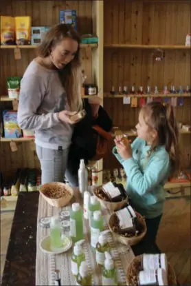  ??  ?? Louisa Heck, of Boyertown, and her daughter Lylah Fay, 5, browse the plant-based beauty products sold at the all-vegan Firefly Café Outpost in Boyertown. The outpost is Pennsylvan­ia’s first all-vegan grocery store.