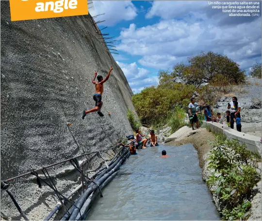  ?? (SIPA) ?? Un niño caraqueño salta en una zanja que lleva agua desde el túnel de una autopista abandonada.