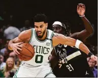  ?? Charles Krupa / Associated Press ?? Boston Celtics forward Jayson Tatum (0) tries to pivot around Milwaukee Bucks guard Jrue Holiday during the first half of Game 5 of an Eastern Conference semifinal Wednesday in Boston.