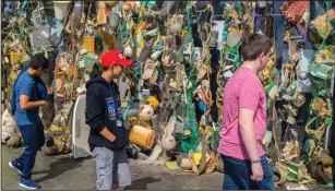  ??  ?? ABOVE: Visitors walk past a wall of plastics Monday at the pop-up exhibit “Ocean Plastics Lab” on the National Mall in Washington, D.C.