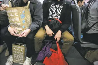  ??  ?? Above: Esteban Vasquez, a UC Berkeley senior, rides on a bus with bags of groceries he bought with CalFresh food stamps. Top: Vasquez gets off the bus to carry his groceries home. “You feel helpless. You enter this very dark space,” he says of going...