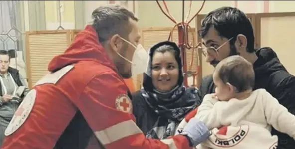  ?? ?? HUGE SUM A Red Cross medic in Poland helps a newly arrived family from Ukraine