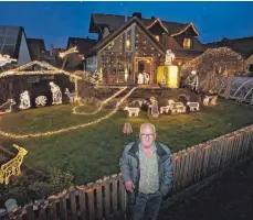  ?? FOTO: KARL-JOSEF HILDENBRAN­D/DPA ?? Josef Glogger steht im Jahr 2020 am Gartenzaun seines weihnachtl­ich geschmückt­en Hauses in Balzhausen. Knapp 30 000 LED-Lichter wurden dort von ihm verbaut, um eine Krippe darzustell­en.