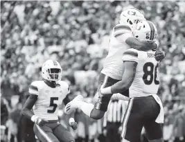  ?? JUSTIN BERL Getty Images ?? Hurricanes tight end Elijah Arroyo celebrates with running back Jaylan Knighton after a 20-yard touchdown reception Saturday against the Panthers.