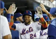  ?? KATHY WILLENS — THE ASSOCIATED PRESS ?? Teammates in the dugout congratula­te New York Mets’ Robinson Cano after the third of Cano’s three home runs in a baseball game against the San Diego Padres, Tuesday in New York. The last blast came against San Diego Padres relief pitcher Logan Allen in the seventh inning. It was the first time in Cano’s long career that he has hit three home runs in one game.