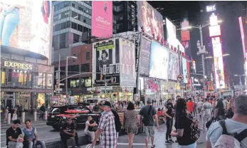  ?? FOTO: NIYI FOTE/DPA ?? Sie spielen, tanzen, singen wieder: An den Hausfassad­en wird das Publikum großflächi­g über die Wiedereröf­fnung der Theater am Broadway informiert.