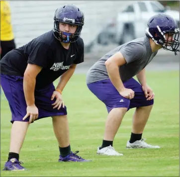  ??  ?? Mayflower senior Daniel Sutton, left, and sophomore Josh Christ await the snap during preseason practcie.