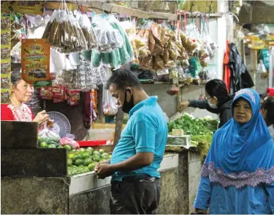  ?? FRIZAL/JAWA POS ?? ABAIKAN PROTOKOL: Sejumlah pedagang dan pengunjung Pasar Wonokromo belum disiplin memakai masker kemarin.